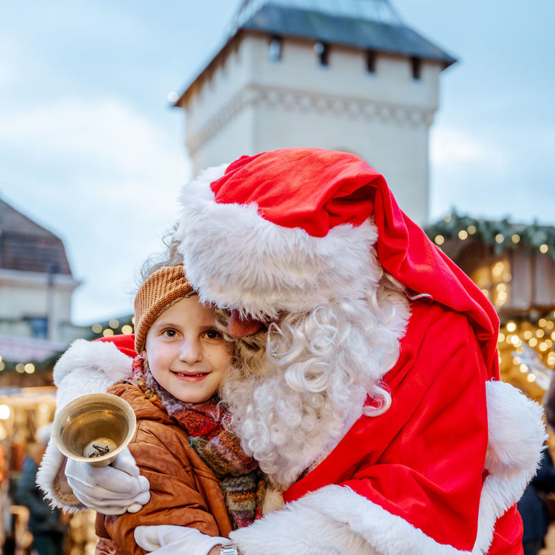 Kerstman knuffelt kind voor Geulpoort in Valkenburg