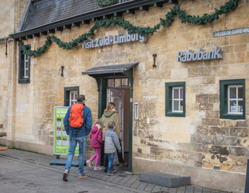 Gezin loopt Visit Zuid-Limburg Experience binnen tijdens Kerststad Valkenburg