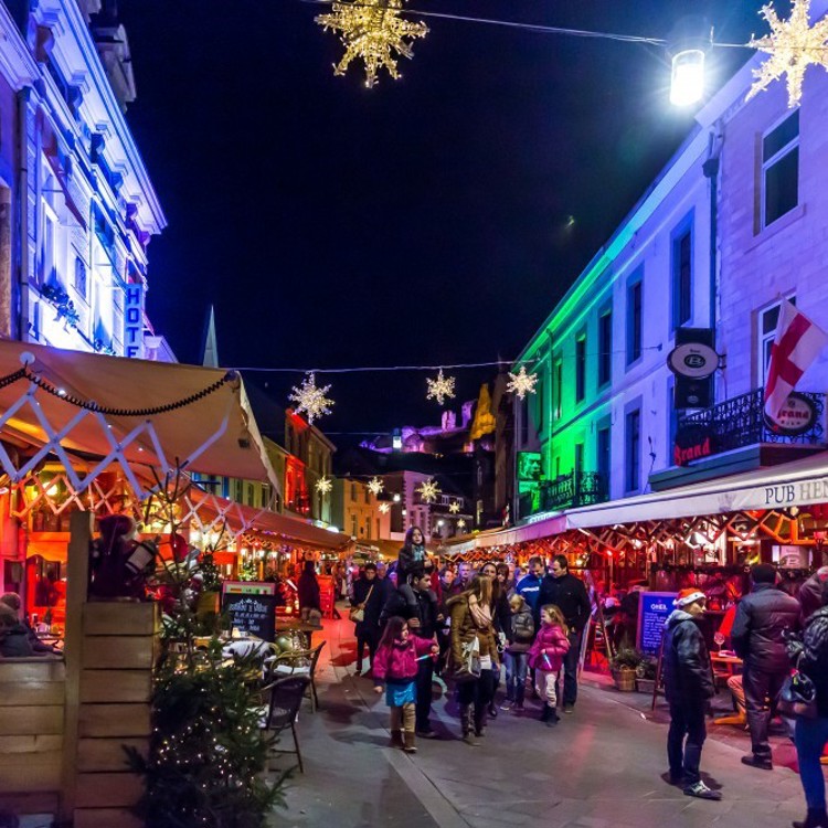 Sfeerfoto van terrassen en struinende mensen tijdens Kerststad Valkenburg in de avond