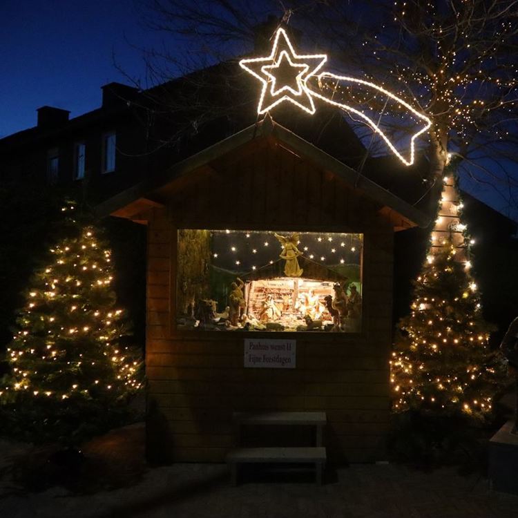 Houten huisje met daarin een verlicht kerststalletje