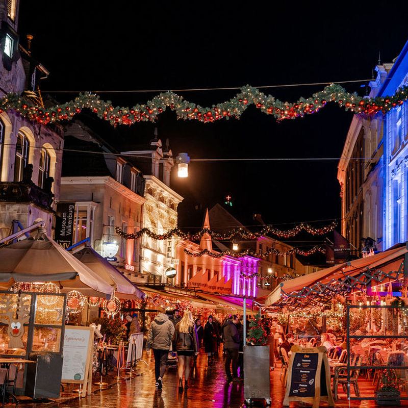 Sfeerbeeld van kerstversiering en terrassen van Valkenburg in de avond