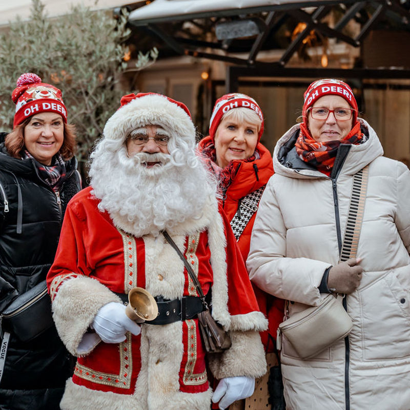 Mensen poseren met kerstmutsen met de kerstman