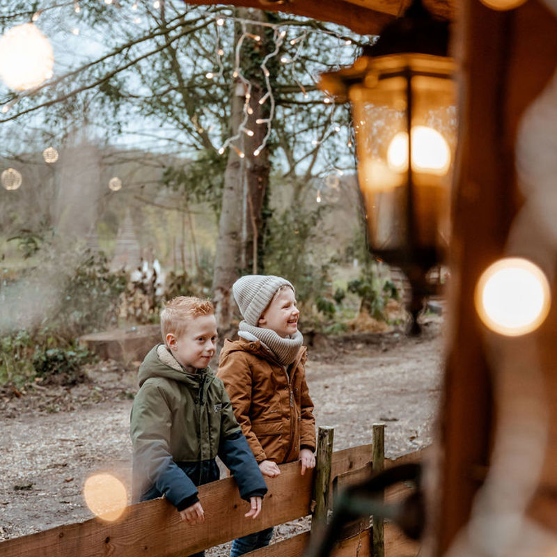 Jongens kijken naar kerststal tijdens de kribkeswandeling Schin op Geul