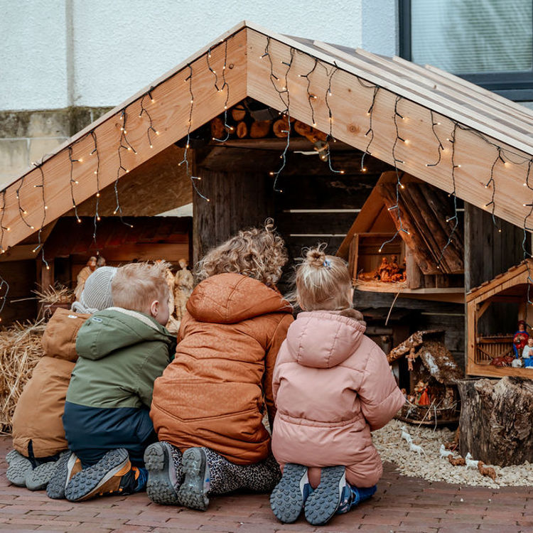 Kindjes op knieën voor kribke